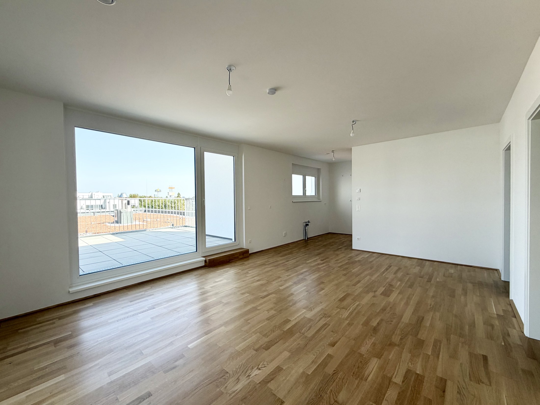 Heller Wohnraum mit Parkett und Zugang zur Terrasse